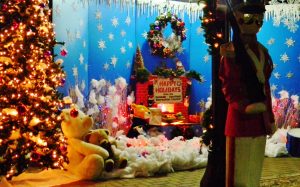 Christmas display window with snow, wreathes, and a nutcracker.
